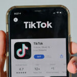 person holding a smartphone with TikTok on its screen